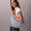 Denim-hobolaukku, jossa on koko pinnan kattava logomerkki