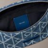 Denim-vyölaukku, jossa on koko pinnan kattava logomerkki