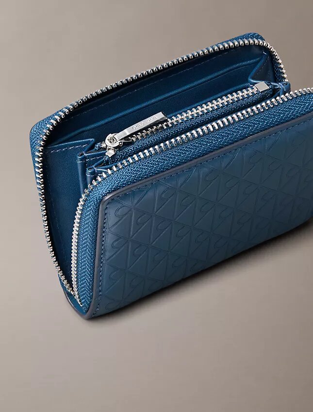 Koko pinnan kattava kohokuvioitu Monogram-kuvioinen vetoketjullinen kolikkopussi Koko pinnan kattava kohokuvioitu Monogram-kuvioinen vetoketjullinen kolikkopussi